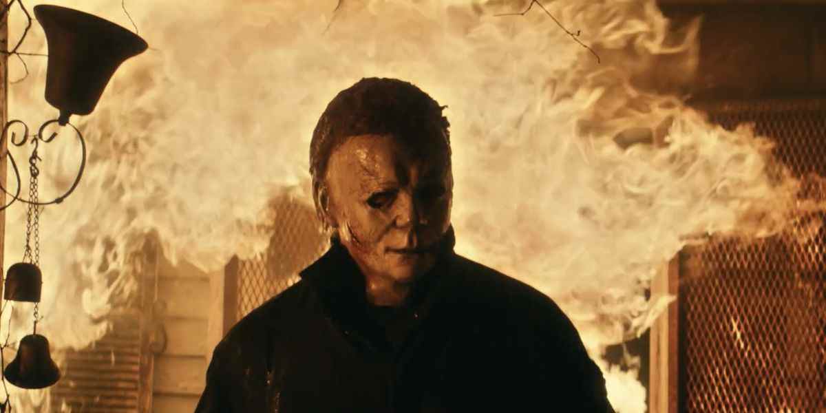 Michael Myers émerge d'une maison en flammes dans Halloween Kills.  L'arrière-plan est principalement une flamme.