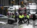 Des policiers patrouillent à pied le long de la rue Albert pour protester contre les restrictions liées à la COVID-19 qui ont été marquées par des embouteillages et le son des klaxons des camions atteint son 14e jour, à Ottawa, le jeudi 10 février 2022.