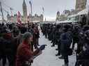 La police intervient pour nettoyer le centre-ville d'Ottawa près de la Colline du Parlement des manifestants après des semaines de manifestations le samedi 19 février 2022.  