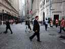 Les gens marchent le long de Wall Street près de la Bourse de New York.