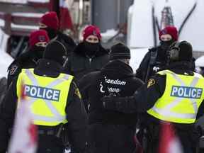 Un camionneur est emmené après avoir quitté son camion alors que la police vise à mettre fin à une manifestation en cours contre les mesures COVID-19 qui s'est transformée en une manifestation antigouvernementale plus large, à Ottawa, le 18 février 2022.