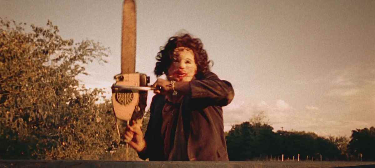 Leatherface poursuit un camion en brandissant une tronçonneuse.