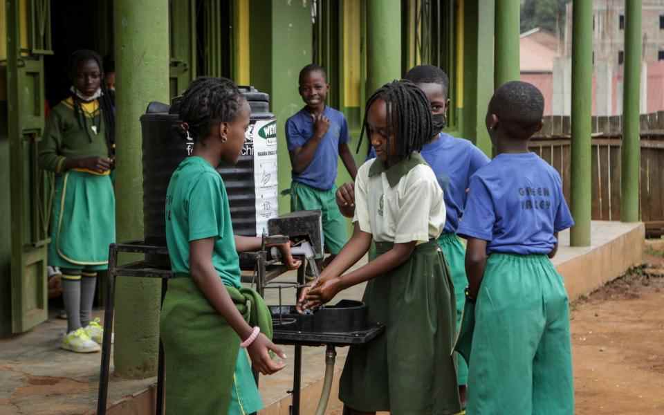 Les élèves se lavent les mains avant d'entrer en classe à l'école primaire Green Valley, l'une des trois à signaler des cas d'Ebola dans la capitale, à Kampala - AP Photo/Hajarah Nalwadda