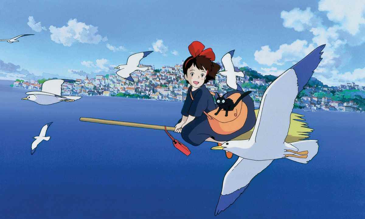 Kiki fait voler son balai au-dessus de la mer dans le film d'animation Kiki's Delivery Service.