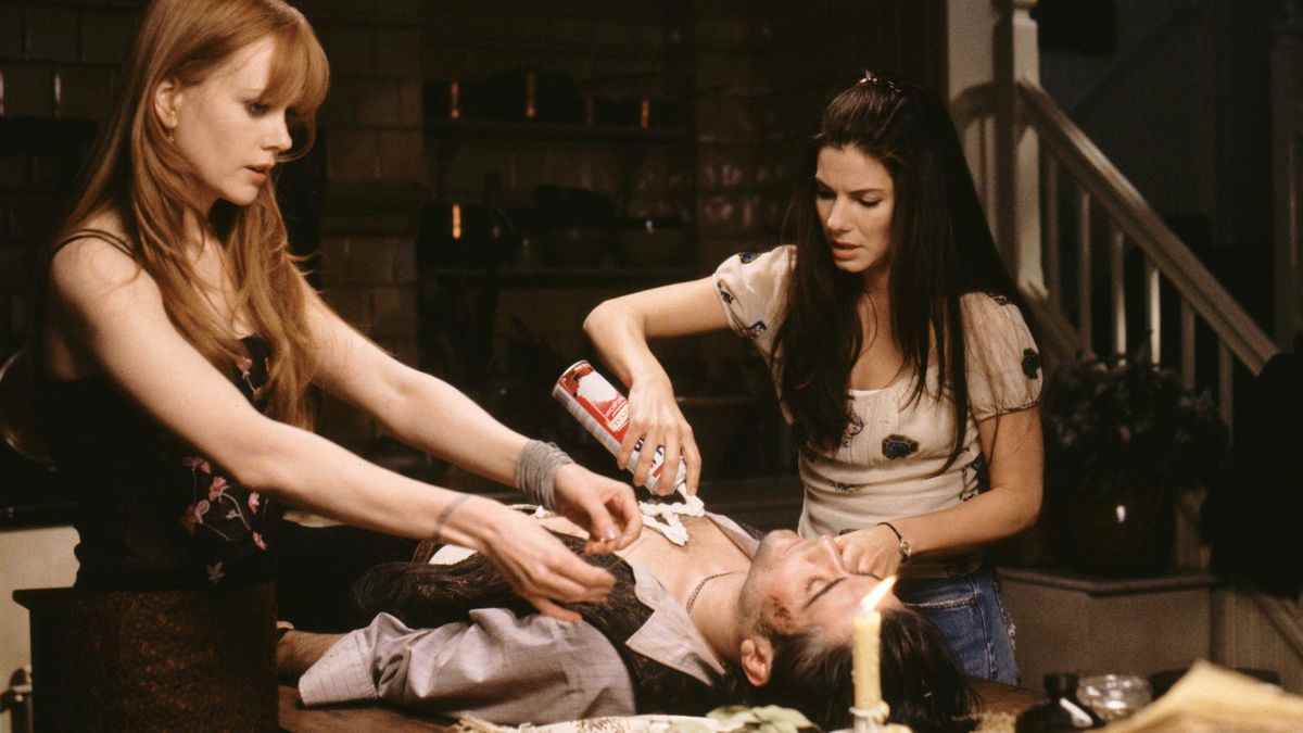 Gillian (Nicole Kidman) et Sally (Sandra Bullock) jettent un sort sur un homme allongé sur une table dans Practical Magic.