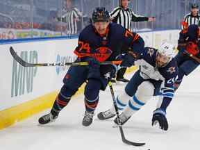 Les défenseurs des Oilers d'Edmonton Ethan Bear (74) et les défenseurs des Jets de Winnipeg Derek Forbort (24) poursuivent une rondelle perdue au cours de la troisième période du premier match des séries éliminatoires de la Coupe Stanley 2021 à Rogers Place.  Perry Nelson-USA AUJOURD'HUI