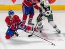 Le défenseur des Canadiens de Montréal Arber Xhekaj tente de rassembler la rondelle contre le centre du Wild du Minnesota Sam Steel lors de la troisième période au Centre Bell de Montréal le 25 octobre 2022.