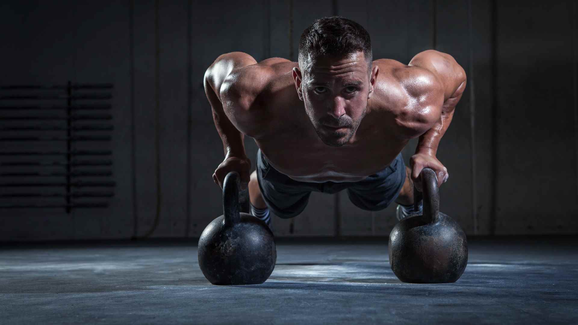 Personne exécutant un burpee push-up kettlebell avec deux kettlebells