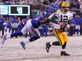 1er décembre 2019 ;  East Rutherford, New Jersey, États-Unis ;  Le quart-arrière des Packers de Green Bay Aaron Rodgers (12 ans) se libère de l'emprise du secondeur des Giants de New York Lorenzo Carter (59 ans) pour lancer une passe de TD au quatrième quart au MetLife Stadium.