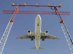 Un vol d'Air Canada effectue son approche finale lorsqu'il atterrit à l'aéroport international Pearson de Toronto, le 30 septembre 2004. La saison des vacances pourrait être affectée par des retards, car la pénurie de main-d'œuvre persistante dans le secteur du transport aérien entraînera des interruptions de service inévitables, déclare le président de l'Association canadienne du contrôle du trafic aérien.