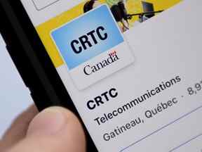 Une personne navigue sur les pages de médias sociaux en ligne du Conseil de la radiodiffusion et des télécommunications canadiennes (CRTC) sur un téléphone cellulaire.