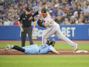 Jesus Aguilar # 99 des Orioles de Baltimore enregistre le dernier retrait d'un triple jeu sur Bo Bichette # 11 des Blue Jays de Toronto au premier but de la troisième manche au Rogers Centre le 18 septembre 2022 à Toronto, Ontario, Canada.