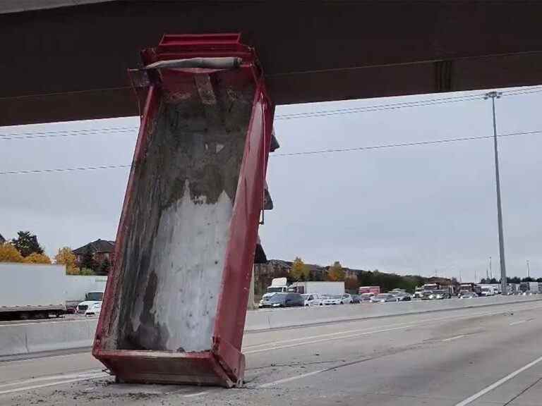 Boîte de camion à benne basculante coincée sous l’autoroute.  Viaduc 401 à Toronto