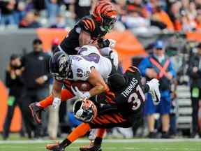 26 décembre 2021 ;  Cincinnati, Ohio, États-Unis ;  Le demi de coin des Bengals de Cincinnati Chidobe Awuzie (22 ans) et le demi défensif Michael Thomas (31 ans) s'attaquent à l'ailier serré des Ravens de Baltimore Mark Andrews (89 ans) en première mi-temps au stade Paul Brown.