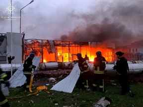 Les pompiers travaillent sur le site d'un immeuble de bureaux d'un détaillant de voitures, détruit lors d'une attaque de missiles russes à Zaporizhzhia, en Ukraine, le 11 octobre 2022.