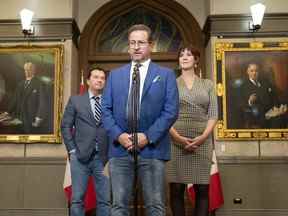 Le député bloquiste de La Prairie Alain Therrien, à gauche, et la députée de Saint-Jean Christine Normandin regardent le chef Yves-François Blanchet s'entretenir avec les journalistes après le rejet d'une motion sur les liens avec la monarchie à Ottawa.