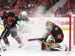 Magnus Hellberg des Sénateurs d'Ottawa effectue un arrêt alors que Radek Faksa des Stars de Dallas pulvérise de la glace à Hellberg sous le regard de Mark Kastelic en première période au Centre Canadian Tire le 24 octobre 2022.