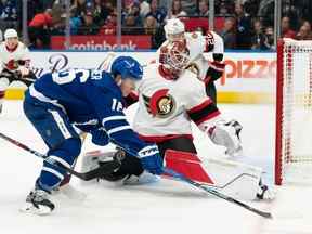 Le gardien de but des Sénateurs d'Ottawa Cam Talbot (33 ans) se bat pour la rondelle avec l'ailier droit des Maple Leafs de Toronto Mitchell Marner (16 ans) lors de la première période au Scotiabank Arena, le 24 septembre 2022.