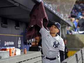 Un garçon de balle des Yankees de New York sèche sur le toit de la pirogue pendant un retard dans le cinquième match de l'ALDS au Yankee Stadium.