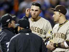 L'arbitre Alfonso Marquez vérifie l'oreille de Joe Musgrove # 44 des Padres de San Diego lors de la sixième manche contre les Mets de New York dans le troisième match de la série Wild Card de la Ligue nationale au Citi Field le 09 octobre 2022 dans le quartier Flushing du Queens arrondissement de New York.