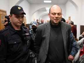 Le militant de l'opposition russe Vladimir Kara-Murza, à droite, est emmené pour une audience à Moscou le 10 octobre 2022. Kara-Murza a été emprisonné en avril pour avoir dénoncé l'offensive du Kremlin en Ukraine et a été accusé de haute trahison, ce qui pourrait le garder derrière les barreaux pendant deux décennies.