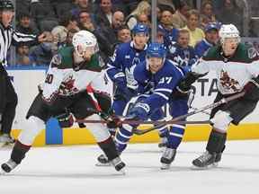 Pierre Engvall des Maple Leafs de Toronto se bat pour la rondelle entre JJ Moser # 90 et Troy Stecher # 51 des Coyotes de l'Arizona lors d'un match de la LNH au Scotiabank Arena le 17 octobre 2022 à Toronto, Ontario, Canada.