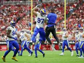 Michael Hoecht # 97 des Rams de Los Angeles célèbre avec l'entraîneur-chef Sean McVay après avoir fait basculer un botté de dégagement par les Cardinals de l'Arizona au cours du premier quart au State Farm Stadium le 25 septembre 2022 à Glendale, Arizona.