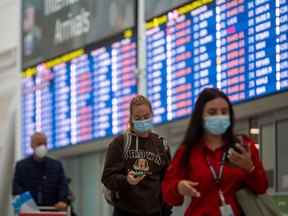 Les voyageurs portent des masques à l'aéroport international Pearson de Toronto le 26 septembre.