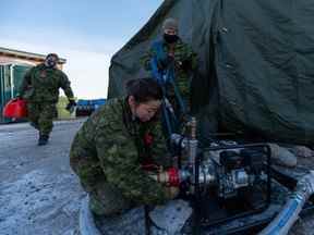 Des membres des Forces armées canadiennes préparent une pompe à eau à Iqaluit, au Nunavut, le mercredi 10 novembre 2021.