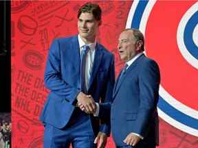 Juraj Slafkovsky serre la main du commissaire de la LNH Gary Bettman après que les Canadiens ont fait de lui le premier choix au repêchage 2022 de la LNH au Centre Bell.