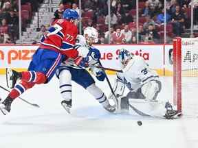 L'attaquant des Canadiens de Montréal Kirby Dach est retenu par le défenseur des Maple Leafs Victor Mete devant le gardien Matt Murray lundi soir au Centre Bell.