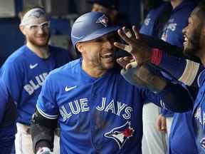 Le voltigeur de centre des Blue Jays George Springer (au centre) célèbre son but contre les Red Sox lors de la cinquième manche au Rogers Centre de Toronto, le samedi 1er octobre 2022.