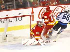 Le gardien des Flames de Calgary Jacob Markstrom est marqué par Mark Scheifele des Jets de Winnipeg hier soir.  Darren Makowichuk/Postmédia