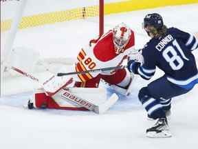 Le gardien des Flames de Calgary Dan Vladar arrête l'attaquant des Jets Kyle Connor lors d'une échappée lors d'un match de pré-saison à Winnipeg mercredi.