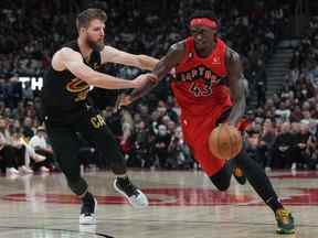 L'attaquant des Raptors Pascal Siakam (43 ans) contrôle le ballon alors que l'attaquant des Cleveland Cavaliers Dean Wade (32 ans) tente de se défendre à la Scotiabank Arena.