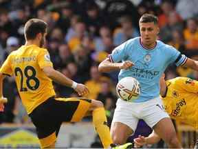 Le milieu de terrain portugais Joao Moutinho (L) de Wolverhampton Wanderers est en concurrence avec le milieu de terrain espagnol Rodri de Manchester City lors du match de football de la Premier League anglaise entre Wolverhampton Wanderers et Manchester City au stade Molineux de Wolverhampton, dans le centre de l'Angleterre, le 17 septembre 2022.