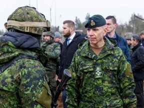 Le chef d'état-major de la Défense, le général Wayne Eyre, à droite, s'entretient avec des soldats lors d'une visite à la base militaire d'Adazi en Lettonie, le 8 mars 2022.