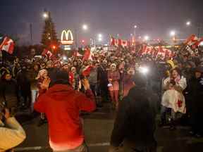 Les manifestants et les partisans votent sur l'opportunité de rester ou de partir avant une date limite d'injonction imminente de 19 heures au pied du pont Ambassador, bloquant le flux de trafic commercial sur le pont vers le Canada depuis Detroit, le 11 février 2022 à Windsor, Ont.