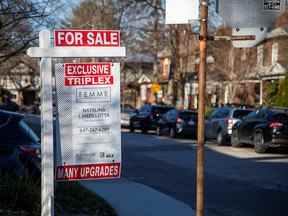 Une enseigne à vendre est affichée à l'extérieur d'une maison à Toronto.