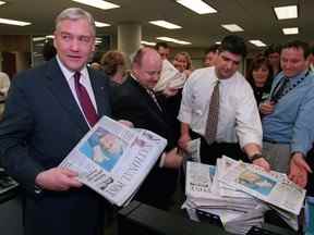 « Plus de mythe que de mortel » : Conrad Black distribue des exemplaires du premier numéro du National Post au personnel du Post dans la salle de rédaction de Toronto, le 27 octobre 1998.