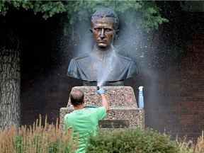 Un bénévole lave la peinture en aérosol de la statue de Roman Shukhevych au Complexe de l'unité de la jeunesse ukrainienne, 9615 153 Ave., à Edmonton le 10 août 2021. David Bloom/Postmedia