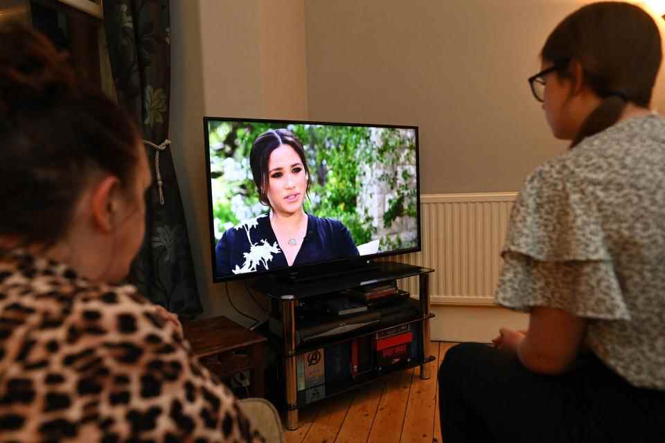 Une famille se rassemble autour de la télévision à Liverpool, dans le nord-ouest de l'Angleterre, pour regarder l'interview explosive du prince Harry et de sa femme Meghan sur CBS avec Oprah Winfrey, le 8 mars 2021, alors que la télévision nationale britannique montre l'interview un jour plus tard, puis aux États-Unis.  - Des pensées suicidaires, un parent raciste et un héritier du trône piégé par la tradition - Le prince Harry et sa femme Meghan ont levé le voile sur la vie au sein de la famille royale britannique avec une interview explosive qui a fait le tour du monde .  (Photo de Paul ELLIS / AFP) (Photo de PAUL ELLIS/AFP via Getty Images)