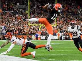 Le receveur large des Browns Donovan Peoples-Jones (au centre) saute par-dessus Jessie Bates III (à gauche) des Bengals lors de la première mi-temps de l'action de la NFL au FirstEnergy Stadium de Cleveland, le lundi 31 octobre 2022.