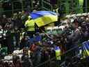 Les spectateurs agitent le drapeau ukrainien avant le début du match de football du groupe F de la Ligue des champions entre le Celtic et le Shakhtar Donetsk au Celtic Park, Glasgow, Écosse, le mardi 25 octobre 2022.