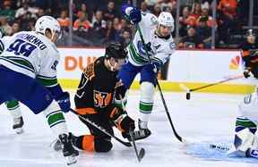 L'ailier droit des Flyers de Philadelphie Wade Allison (57) et le défenseur des Canucks de Vancouver Oliver Ekman-Larsson (23) se battent pour une rondelle libre en première période au Wells Fargo Center.