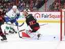 OTTAWA, CANADA - 08 NOVEMBRE: Oliver Ekman-Larsson # 23 (non illustré) marque contre Cam Talbot # 33 des Sénateurs d'Ottawa alors que Brock Boeser # 6 regarde dans la troisième période du match au Centre Canadian Tire le 08 novembre 2022 à Ottawa