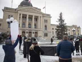 Les participants écoutent un discours prononcé lors d'une manifestation de solidarité et l'appel à l'action est une manifestation qui se tient à l'édifice législatif.