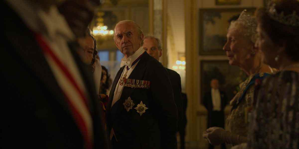 Jonathan Pryce dans le rôle du prince Philip regardant quelqu'un lors d'une fête