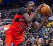 L'attaquant des Raptors de Toronto Chris Boucher (25 ans) tire le ballon tandis que l'attaquant des Indiana Pacers Aaron Nesmith (23 ans) défend au deuxième quart au Gainbridge Fieldhouse.