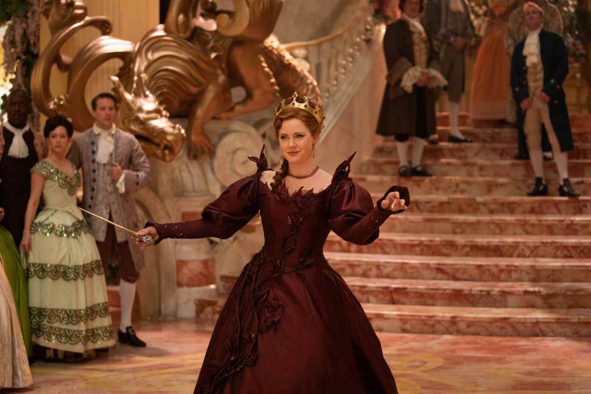 Giselle porte une robe rouge foncé lorsqu'elle entre dans une salle de bal, on dirait qu'elle complote